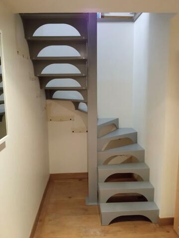 Escalier moderne en métal gris avec des marches en bois clair et un design épuré.